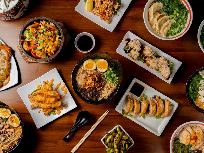 Bakudan Ramen signature dishes spread - ramen bowls, gyoza, takoyaki, and appetizers